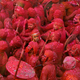Men daubed in colours take part in Lathmar Holi celebrations.